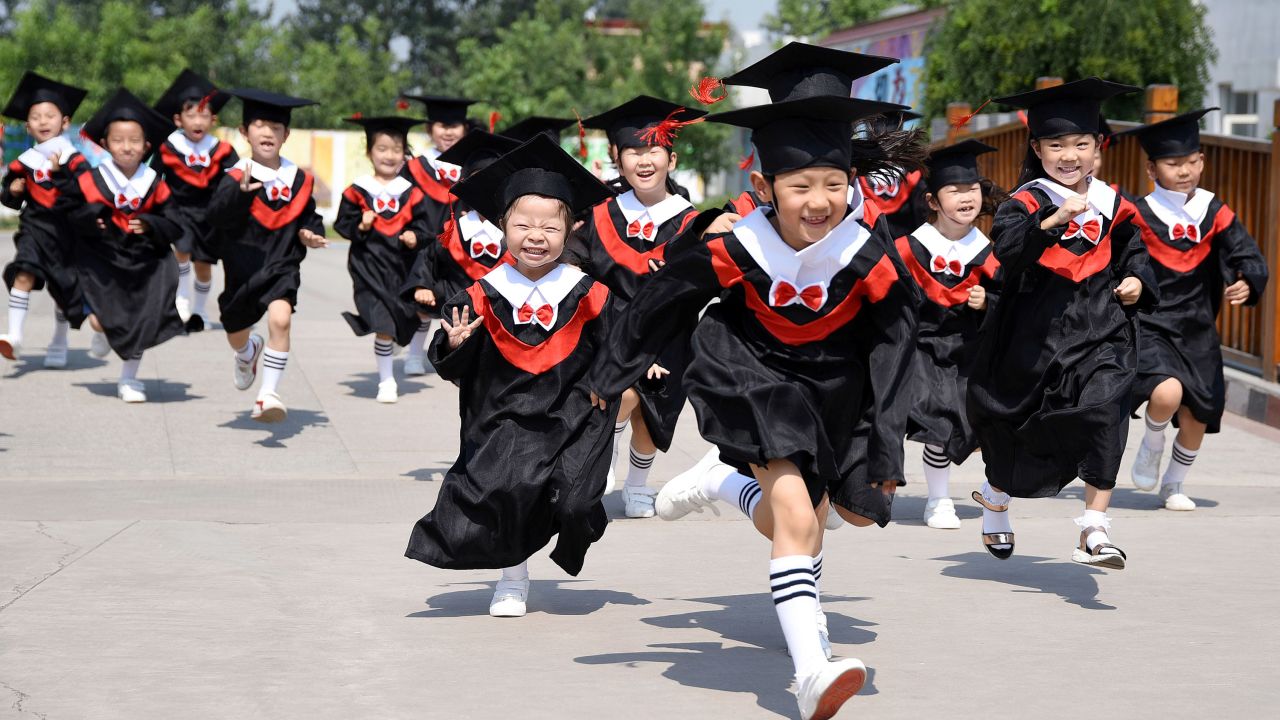 Children run in Handan, China, after graduating from kindergarten on Tuesday, June 20.