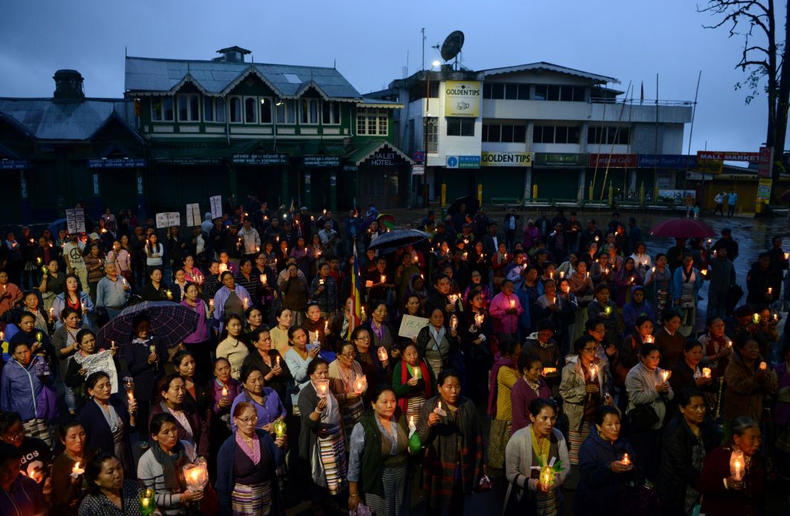 Indian Buddhists hold candles as they take part in a vigil to pay respects to those killed in clashes with police during an indefinite strike in Darjeeling on June 19, 2017.

