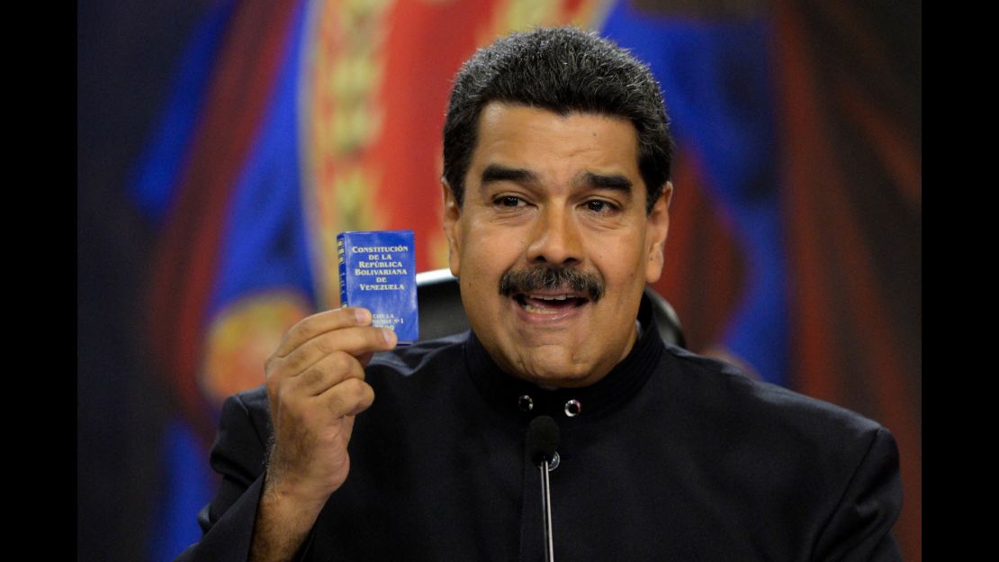Venezuelan President Nicolas Maduro holds up a copy of the Venezuelan constitution during a news conference at the presidential palace in Caracas on June 22. 