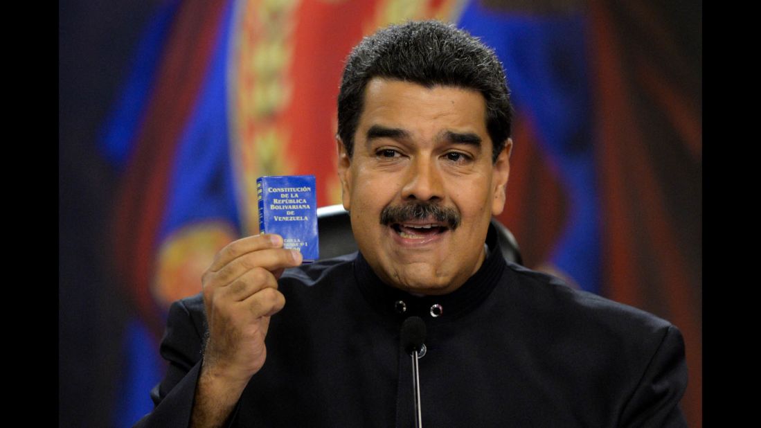Maduro holds up a copy of the Venezuelan constitution during a news conference at the presidential palace in Caracas on June 22. Maduro has called for changes to the constitution amid the unrest.