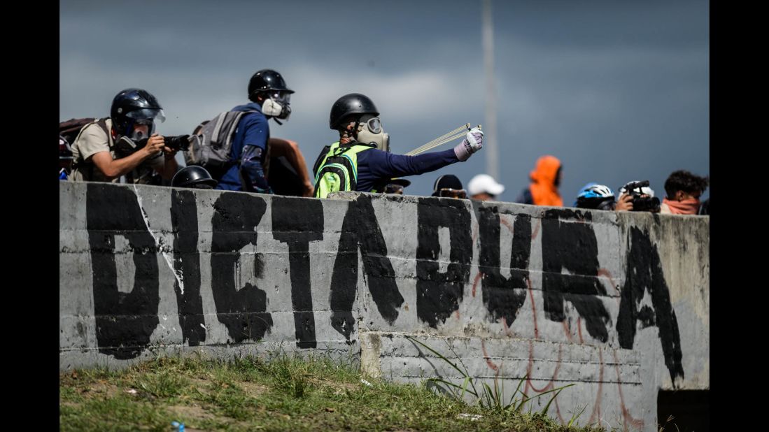 Opposition activists aim projectiles toward riot police during a demonstration on June 19.