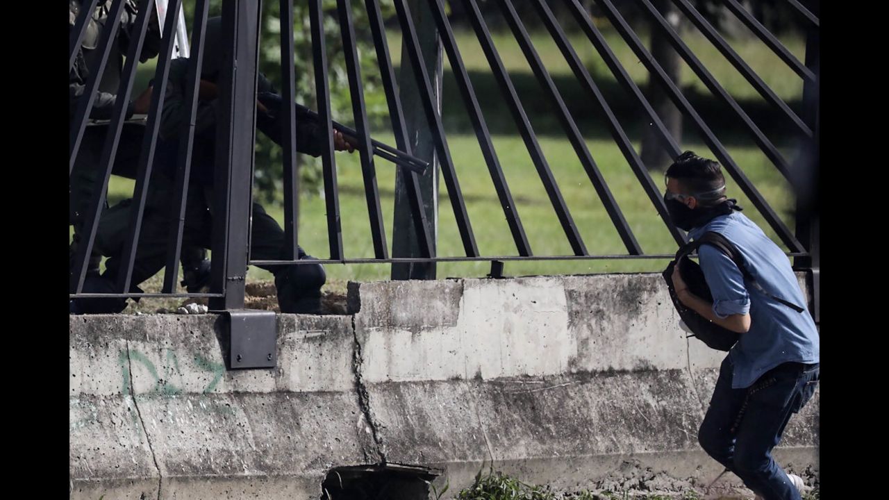 Protester David Jose Vallenilla is shot through a fence by a member of the National Guard near a military base in Caracas on Thursday, June 22. Vallenilla later died in the hospital after suffering three gunshot wounds to the chest. 