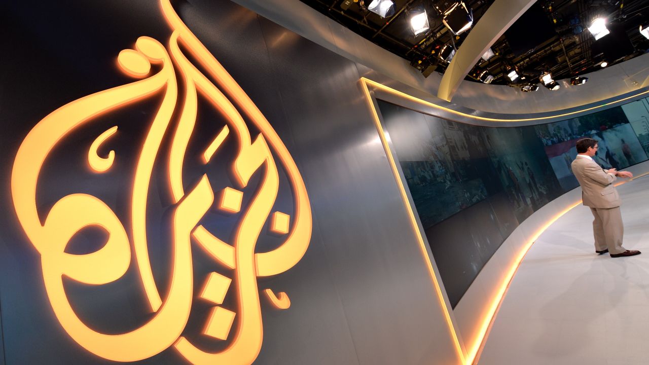 The Al Jazeera logo is seen in the new Al Jazeera America television broadcast studio on West 34th Street August 16, 2013 in New York as Paul Eedle (R), Deputy Launch Manager for Programing speaks to media during a tour. Al Jazeera America, which will launch on August 20, will have its headquarters in New York. AFP PHOTO/Stan HONDA        (Photo credit should read STAN HONDA/AFP/Getty Images)