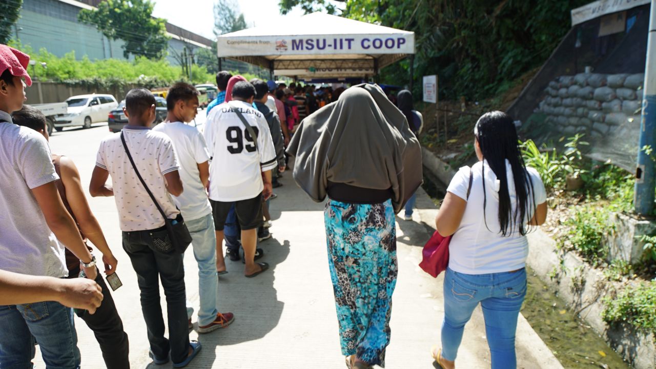 Those wishing to enter the city limits must stand in the sweltering summer heat before having their belongings searched and documnets checked.