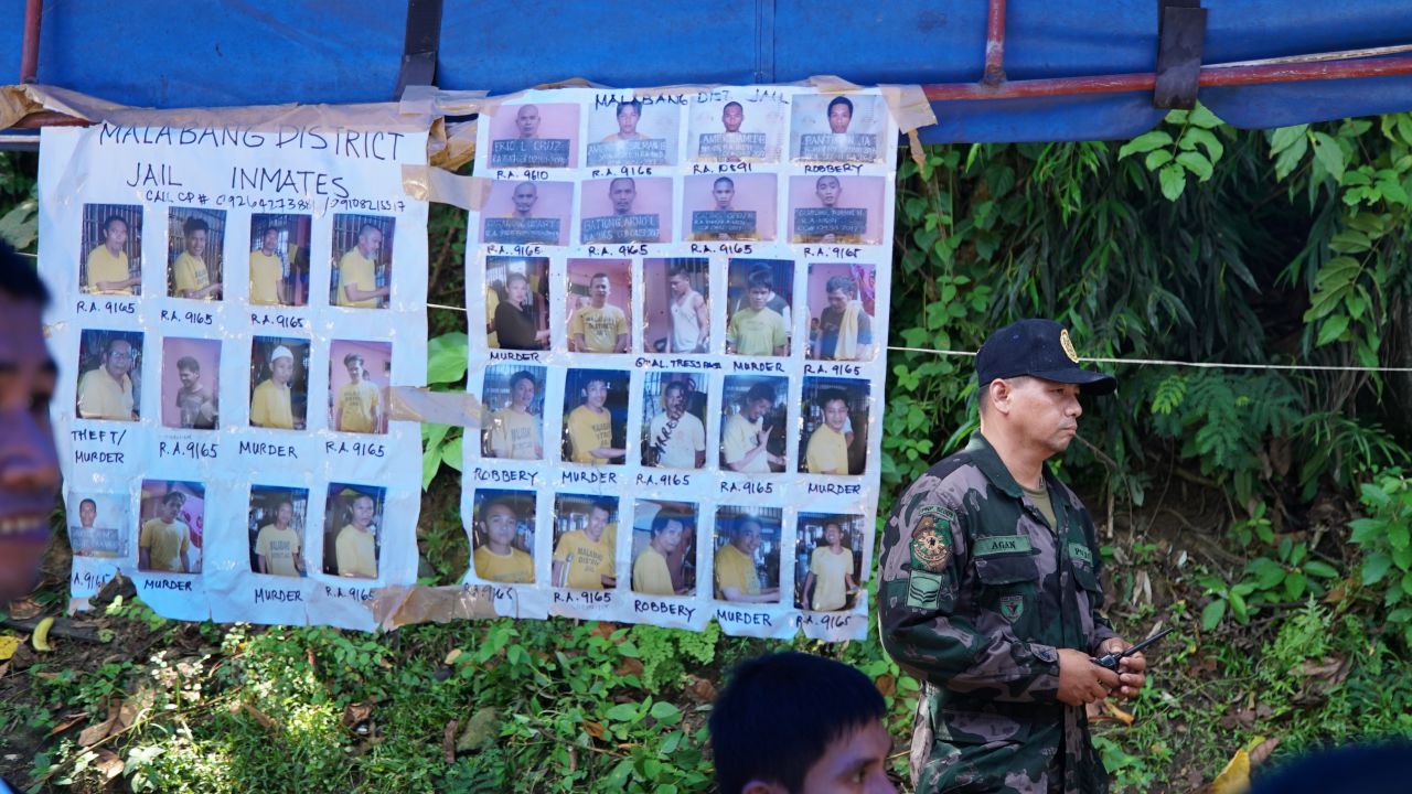 Posters featuring mugshots of suspected militants and escaped convicts hang under the awnings of a government checkpoint outside Iligan City in Mindanao.