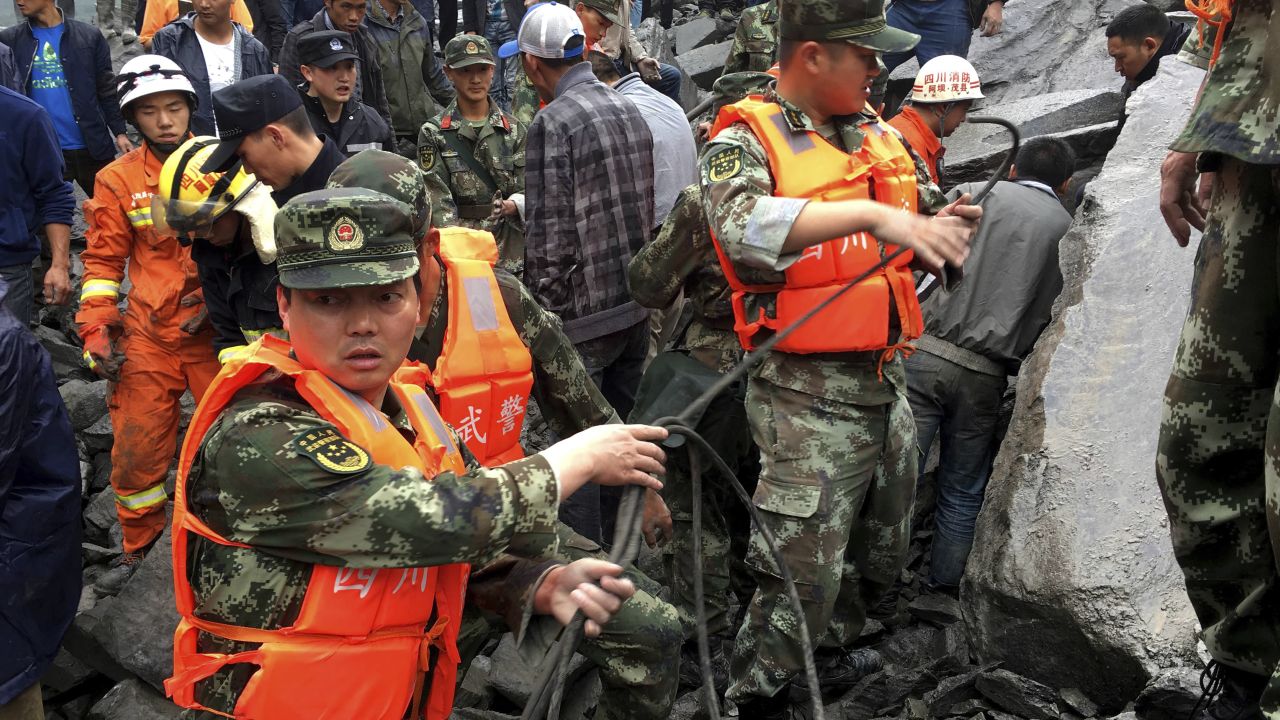 Emergency personnel work at the site of the massive landslide on June 24.