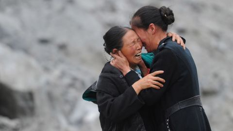 Two people cry among the rubble on June 25.