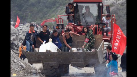 Volunteers deliver supplies to the site of a landslide on June 25. 