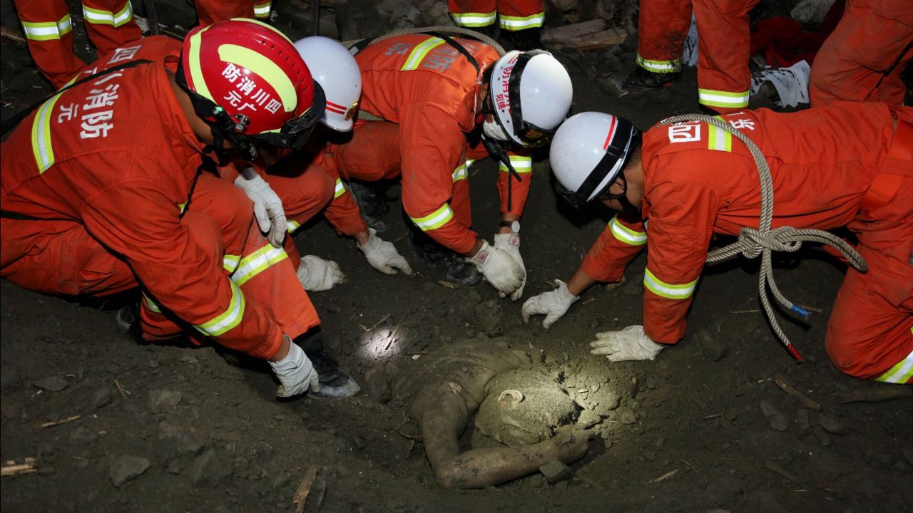 Rescue workers uncover the body of a victim June 24.