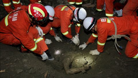 Rescue workers uncover the body of a victim June 24.