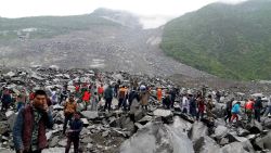 TOPSHOT - CORRECTION - Chinese military police and rescue workers are seen at the site of a landslide in in Xinmo village, Diexi town of Maoxian county, Sichuan province on June 24, 2017. 
Around 100 people are feared buried after a landslide smashed through their village in southwest China's Sichuan Province early Saturday, local officials said, as they launched an emergency rescue operation. / AFP PHOTO / STR / China OUT / The erroneous mention[s] appearing in the metadata of this photo by STR has been modified in AFP systems in the following manner: [Maoxian] instead of [Maoxiang]. Please immediately remove the erroneous mention[s] from all your online services and delete it (them) from your servers. If you have been authorized by AFP to distribute it (them) to third parties, please ensure that the same actions are carried out by them. Failure to promptly comply with these instructions will entail liability on your part for any continued or post notification usage. Therefore we thank you very much for all your attention and prompt action. We are sorry for the inconvenience this notification may cause and remain at your disposal for any further information you may require.        (Photo credit should read STR/AFP/Getty Images)
