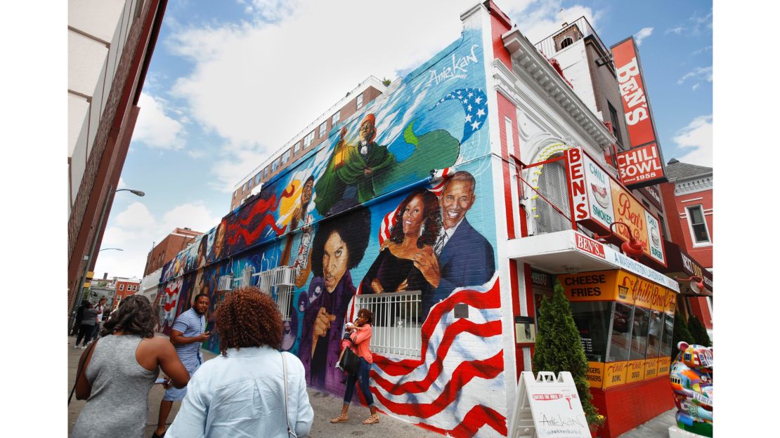People take pictures of the new mural at Ben's Chili Bowl, Friday, June 23, 2017, in Washington.