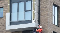 Workers remove panels of external cladding from the facade of a building in the Wythenshawe area of Manchester, northwest England, on June 25, 2017.
The Wythenshawe Community Housing Group (WCHG) which run the development the building is part of took the decision, announced in a June 22 statement, to remove 78 feature panels of external cladding from the development after fire safety tests in the wake of the Grenfell Tower fire. Some 34 high-rise buildings in 17 local authorities in England have already failed urgent fire tests conducted after Grenfell, the government announced June 24, raising fears that thousands more may need to leave their homes. / AFP PHOTO / PAUL ELLIS        (Photo credit should read PAUL ELLIS/AFP/Getty Images)
