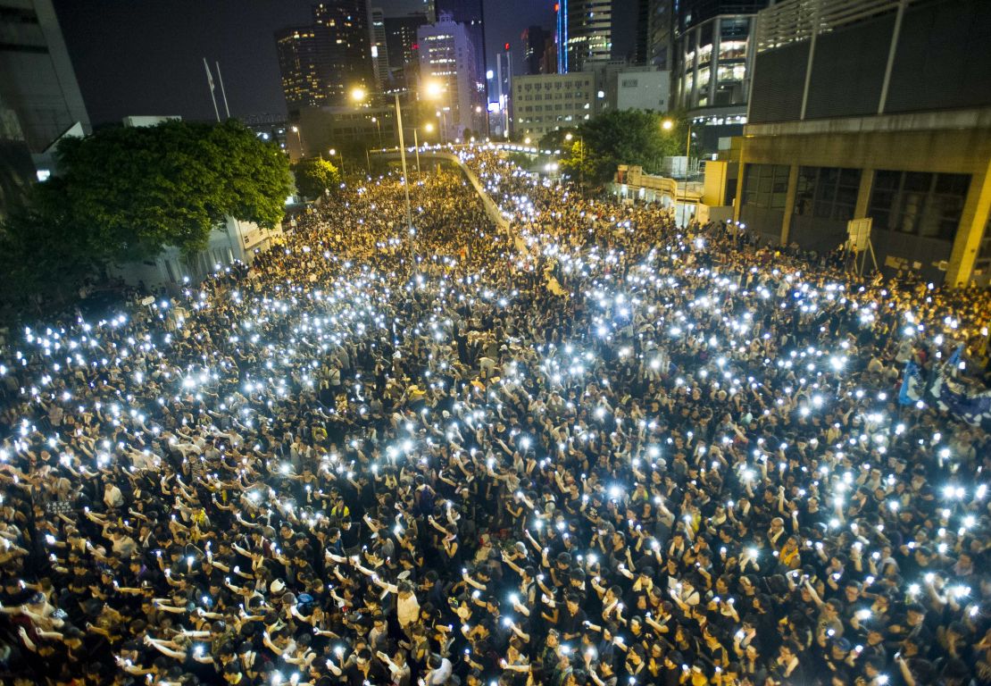 Protestors hold up their cellphones in a display of solidarity during a protest outside the headquarters of Legislative Council in Hong Kong on September 29, 2014.