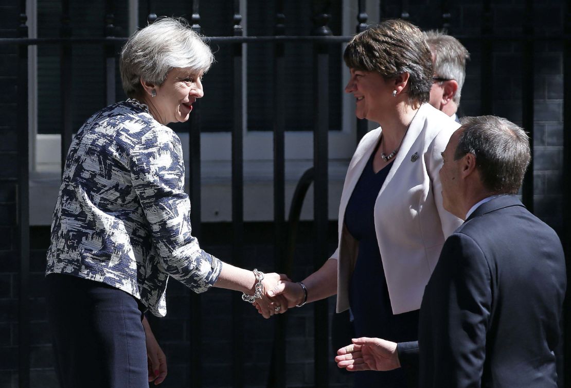Theresa May (L) shakes hands with DUP leader Arlene Foster.