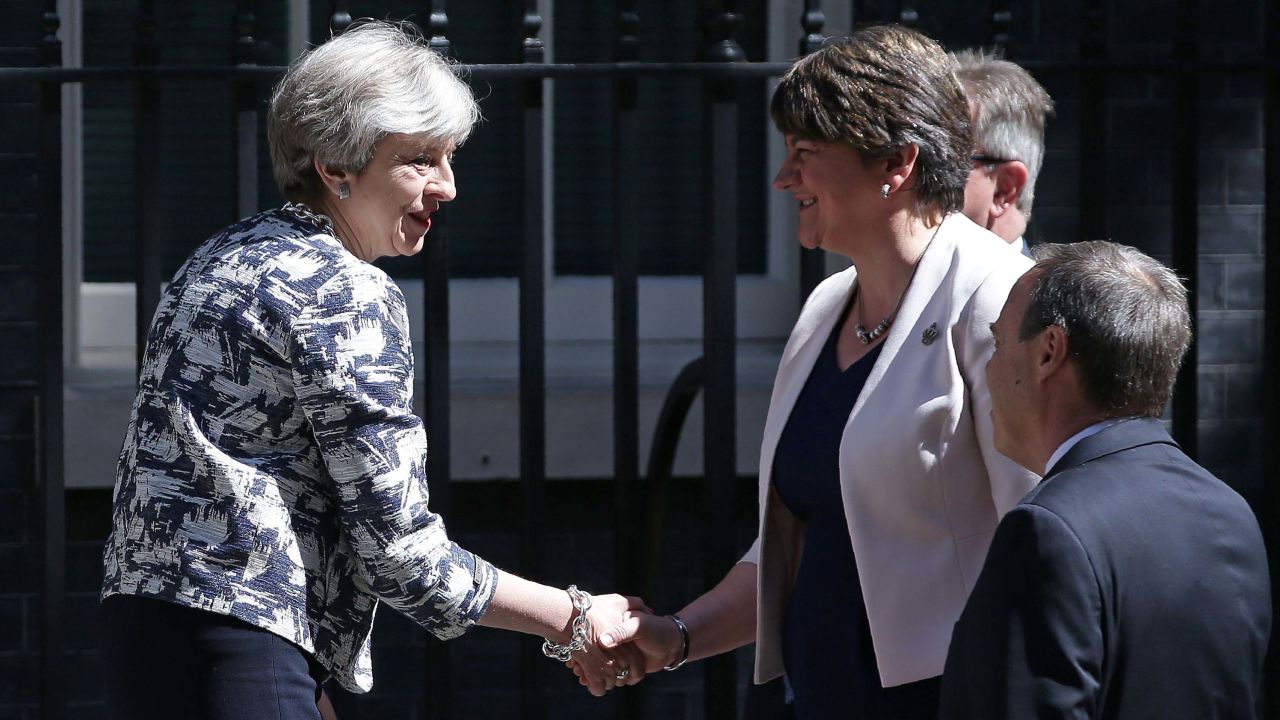 Theresa May (L) shakes hands with DUP leader Arlene Foster.