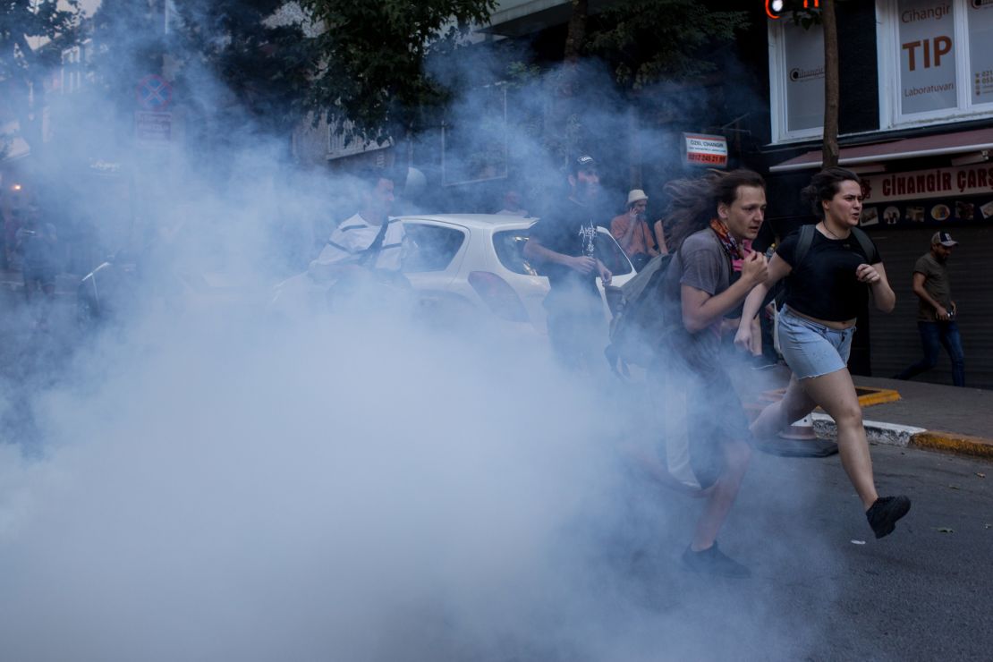 LGBT supporters run from tear gas fired by police after attempting to march to Taksim Square.