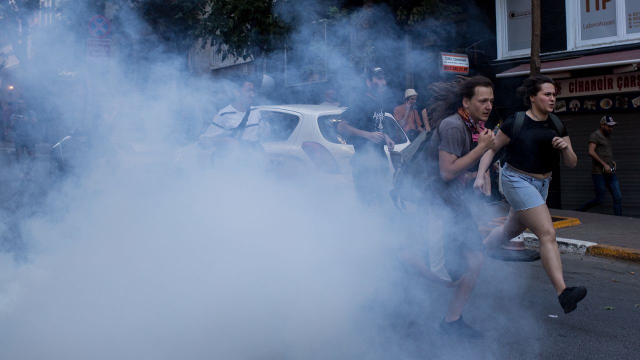 LGBT supporters run from tear gas fired by police after attempting to march to Taksim Square.