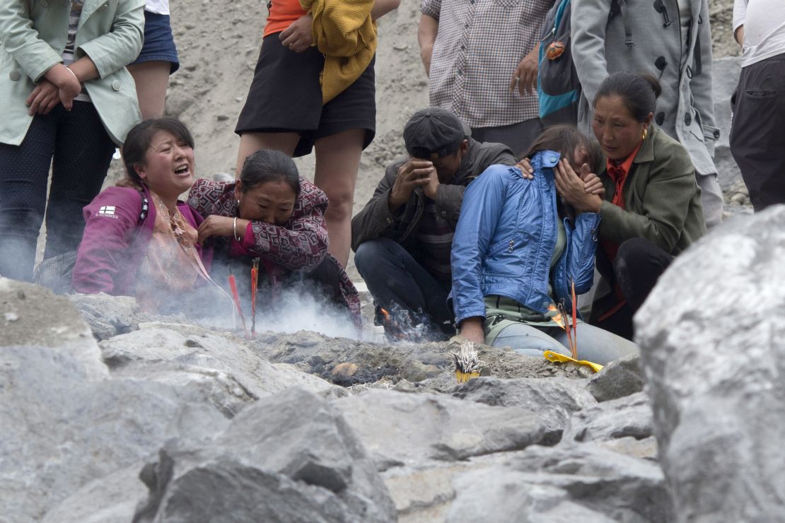 Family members grieve at the site of a landslide in Xinmo village on Sunday, June 25, 2017. 