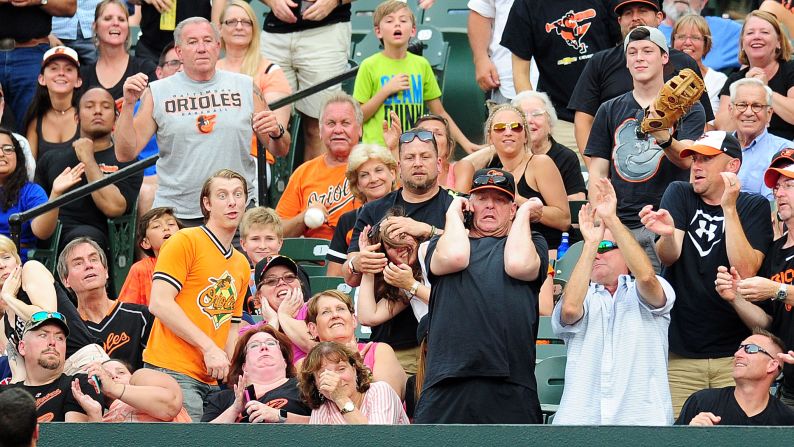 Fans react as a foul ball lands near them in Baltimore on Thursday, June 22.