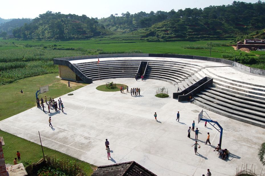 Designed to blend into the surrounding rice terraces, the classrooms of the Qinmo Primary School are hidden beneath a staircase that rises from the basketball court. 