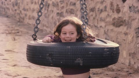Lindsey Averill, around 4 years old, playing in a tire swing.
