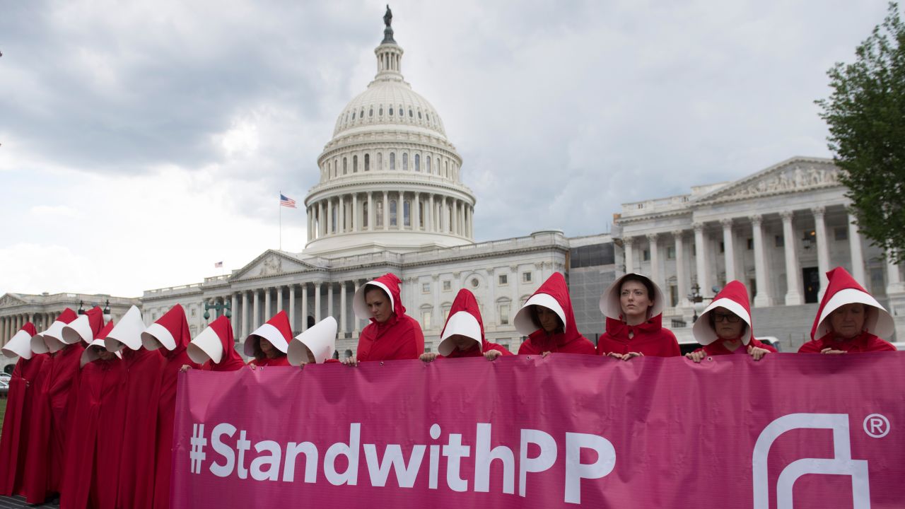 Supporters of Planned Parenthood dressed as characters from "The Handmaid's Tale," hold a rally as they protest the US Senate Republicans' healthcare bill outside the US Capitol in Washington, DC, June 27, 2017. / AFP PHOTO / SAUL LOEB        (Photo credit should read SAUL LOEB/AFP/Getty Images)
