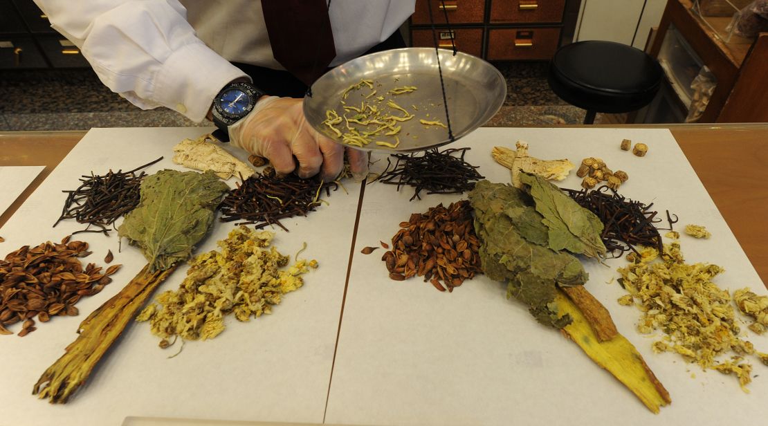 Workers at a traditional chinese medicine store prepare various dried items at a shop in Hong Kong.