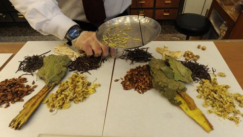 Workers at a traditional chinese medicine store prepare various dried items at a shop in Hong Kong.