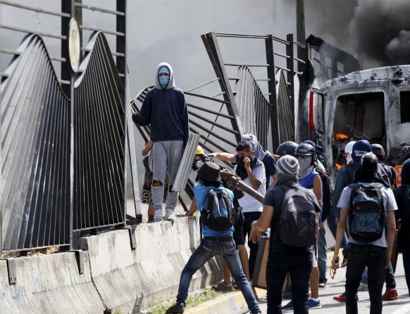 Protesters tear down a fence at the La Carlota airbase outside Caracas on Friday, June 23. A soldier <a href="index.php?page=&url=http%3A%2F%2Fwww.cnn.com%2F2017%2F06%2F23%2Famericas%2Fvenezuela-protest-shooting-video%2Findex.html">shot a demonstrator through the fence </a>at the base on the previous day, killing him.