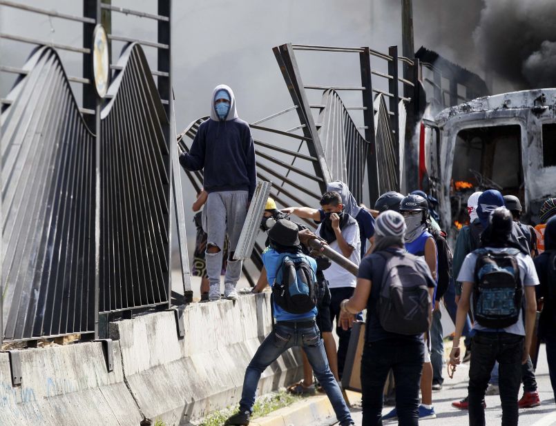 Protesters tear down a fence at the La Carlota airbase outside Caracas on Friday, June 23. A soldier <a href="http://www.cnn.com/2017/06/23/americas/venezuela-protest-shooting-video/index.html">shot a demonstrator through the fence </a>at the base on the previous day, killing him.