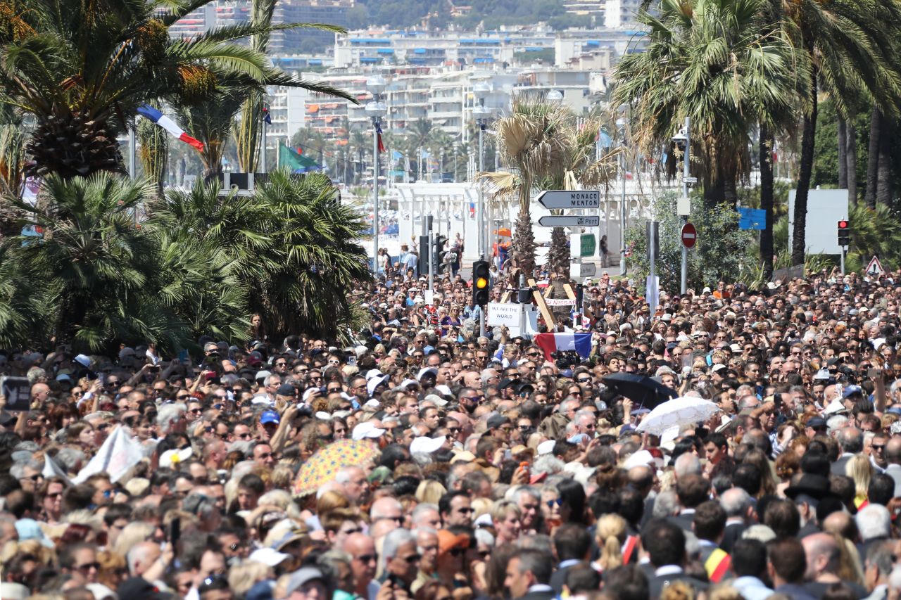 A French flag was raised as people gathered to observe a minute's silence at the Jardin Albert 1er on the Promenade des Anglais seafront in Nice in tribute to the victims of the deadly Nice attack on Bastille Day.