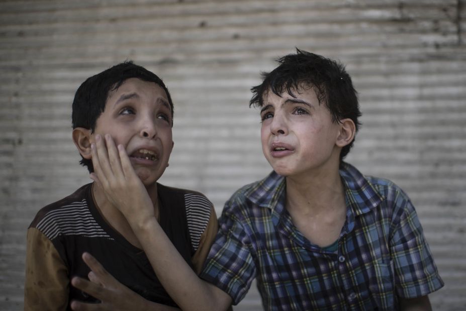 Two boys comfort each other after their home collapsed during fighting between Iraqi forces and militants in Mosul on Saturday, June 24. The boys, who are cousins, said some of their relatives were still under the rubble.