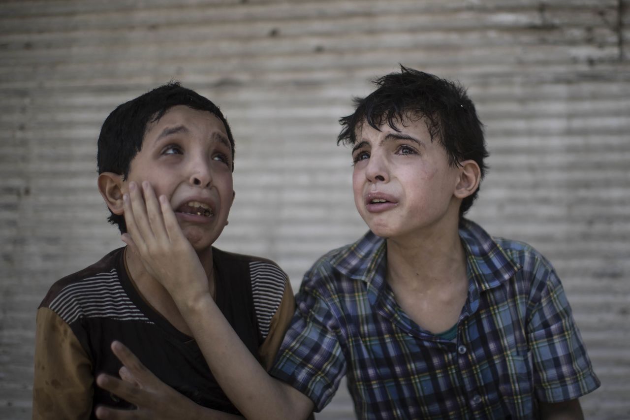 Two boys comfort each other after their home collapsed during fighting between Iraqi forces and militants in Mosul on Saturday, June 24. The boys, who are cousins, said some of their relatives were still under the rubble.