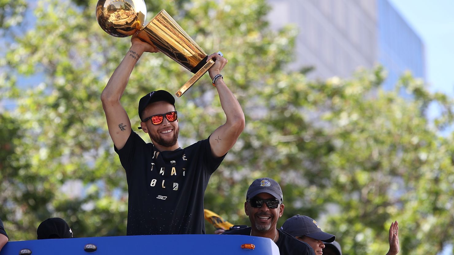Steph Curry holds the Larry O'Brien NBA Championship Trophy aloft during a victory parade in Oakland, California.