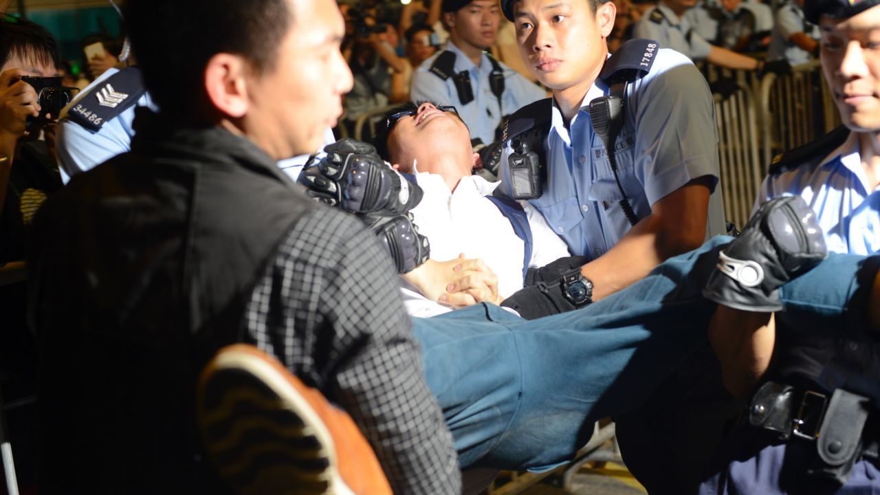 Activist Joshua Wong is arrested Wednesday in Hong Kong's Golden Bauhinia Square.