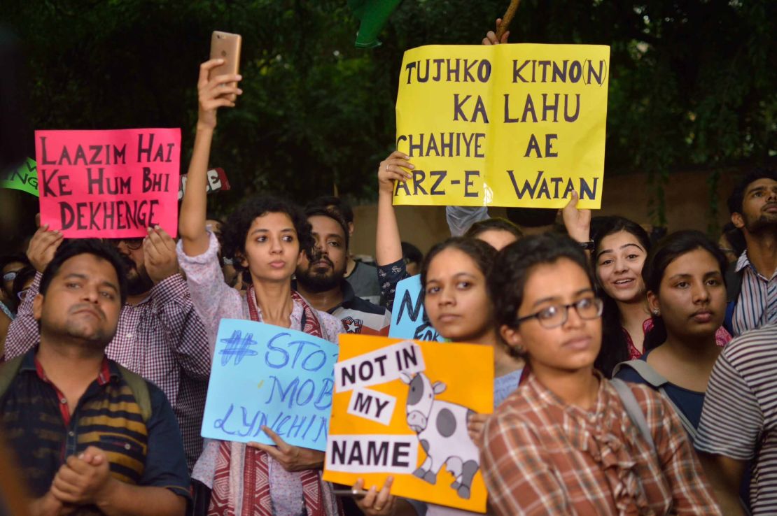 Protestors hold up signs in New Delhi.