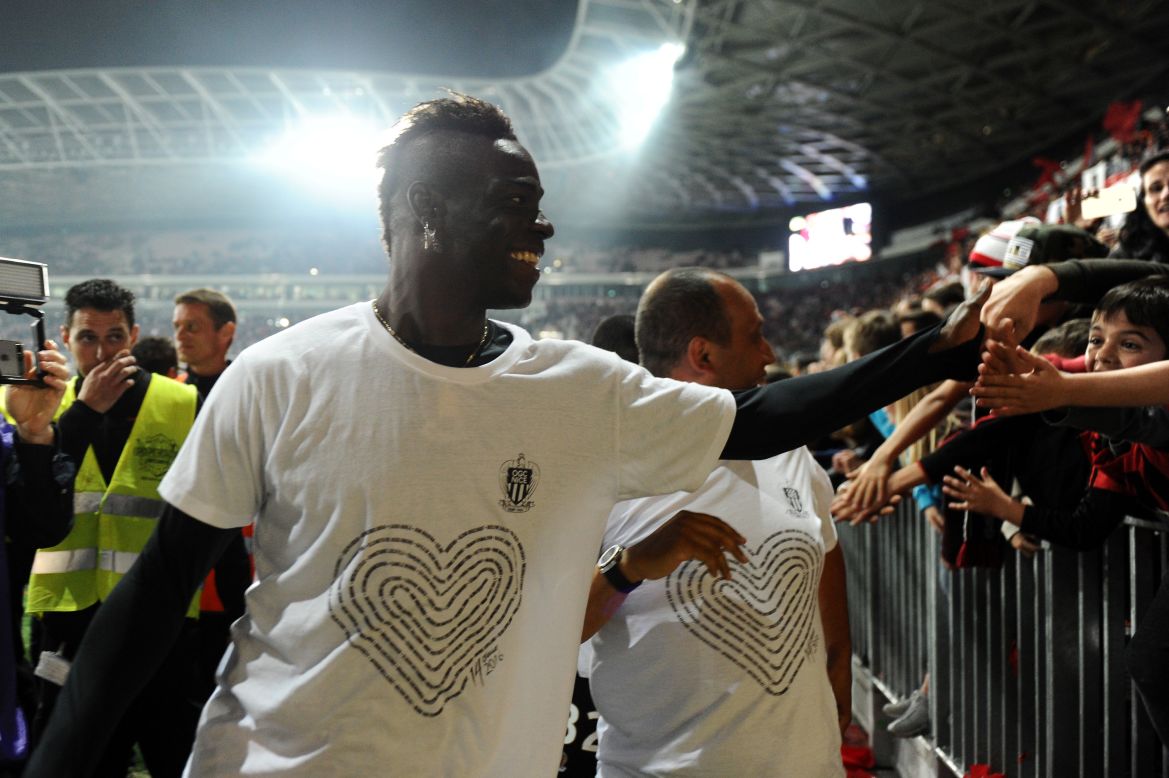 Nice forward Mario Balotelli celebrates with local supporters at the end of a French Ligue 1 football match in May. The striker dons a T-shirt which spells out the names of the 86 victims of the July 14, 2016 terror attack in the shape of a heart. The shirts were sold to raise money for the victims' families.