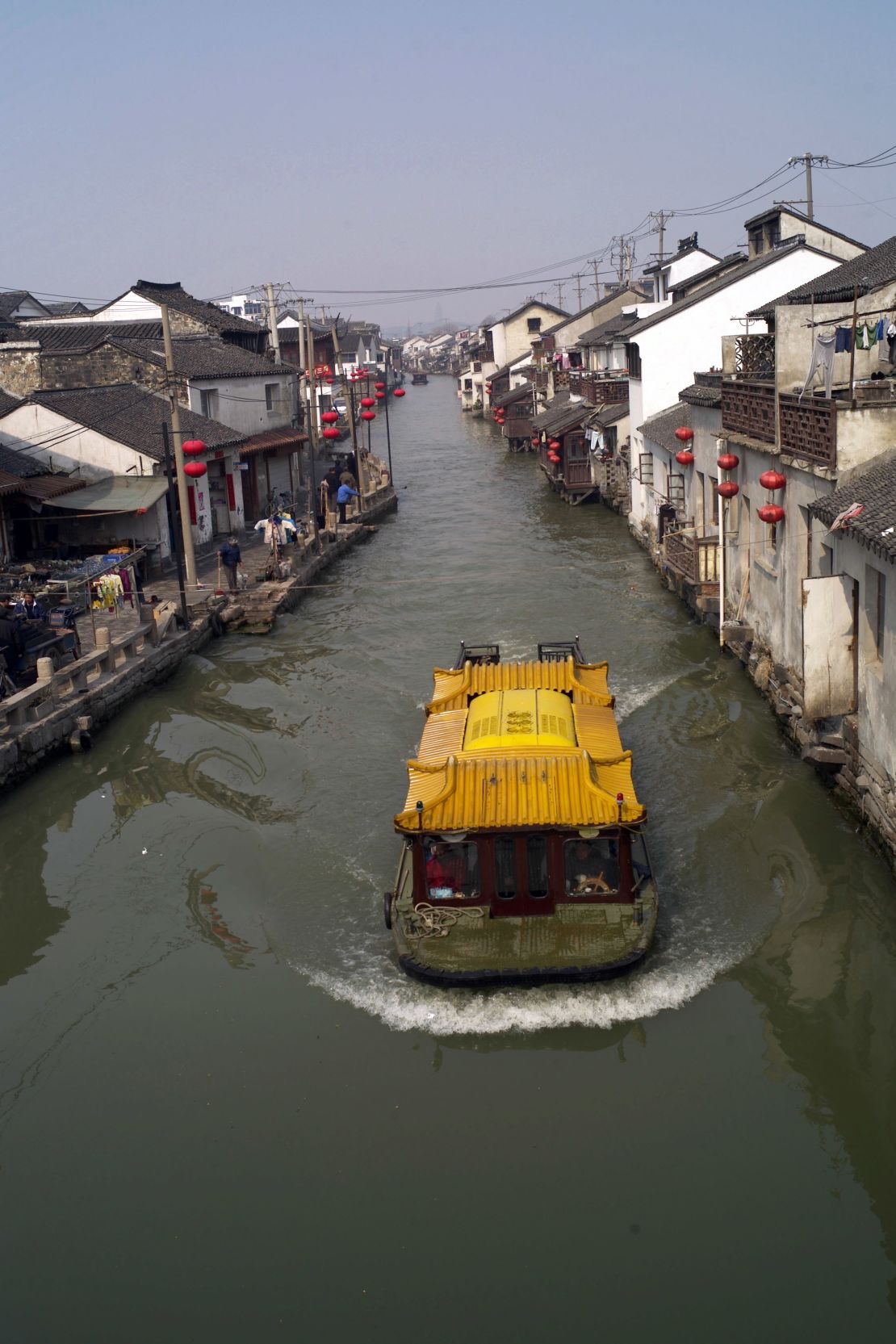A sightseeing boat sails on a canal in Suzhou.