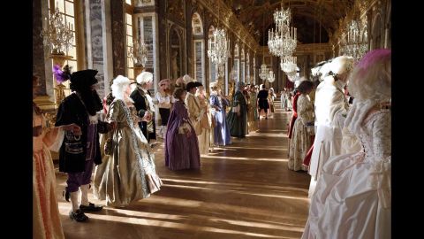 People dressed in period costumes learn dance moves in the Galerie des Glaces, or Hall of Mirrors, at Versailles.