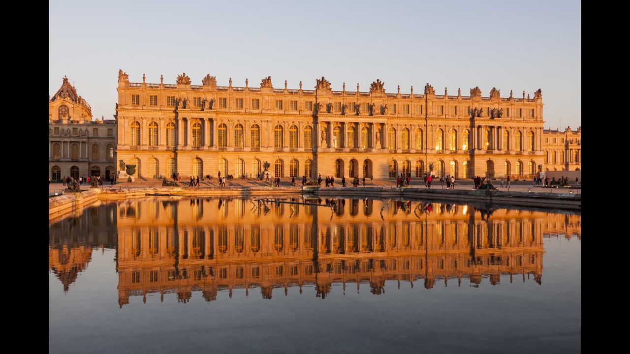Versailles seen reflected in a pool at sunset.