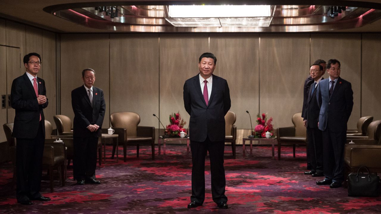 Xi Jinping (C) waits to meet with Hong Kong's chief executive Leung Chun-ying at a hotel in Hong Kong on June 29.