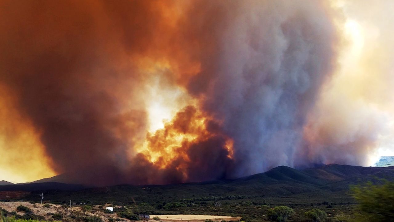 In this Tuesday, June 27, 2017 frame from video, flames and smoke rise from a fire near Mayer, Ariz. The Arizona fire forced the evacuation of Mayer along with several other mountain communities in the area.