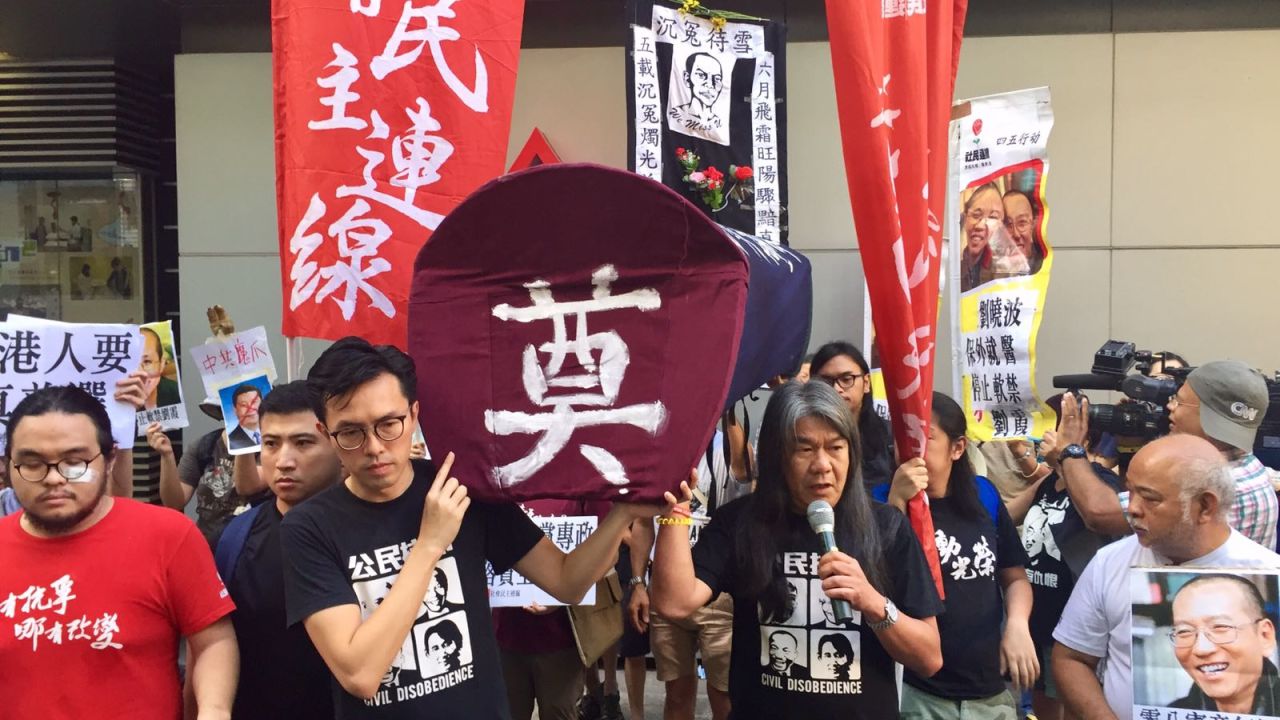 Hong Kong lawmaker Leung Kwok-hung (right) at a pro-democracy rally Saturday. Protesters were prevented from leaving the venue by pro-China counter demonstrators. 