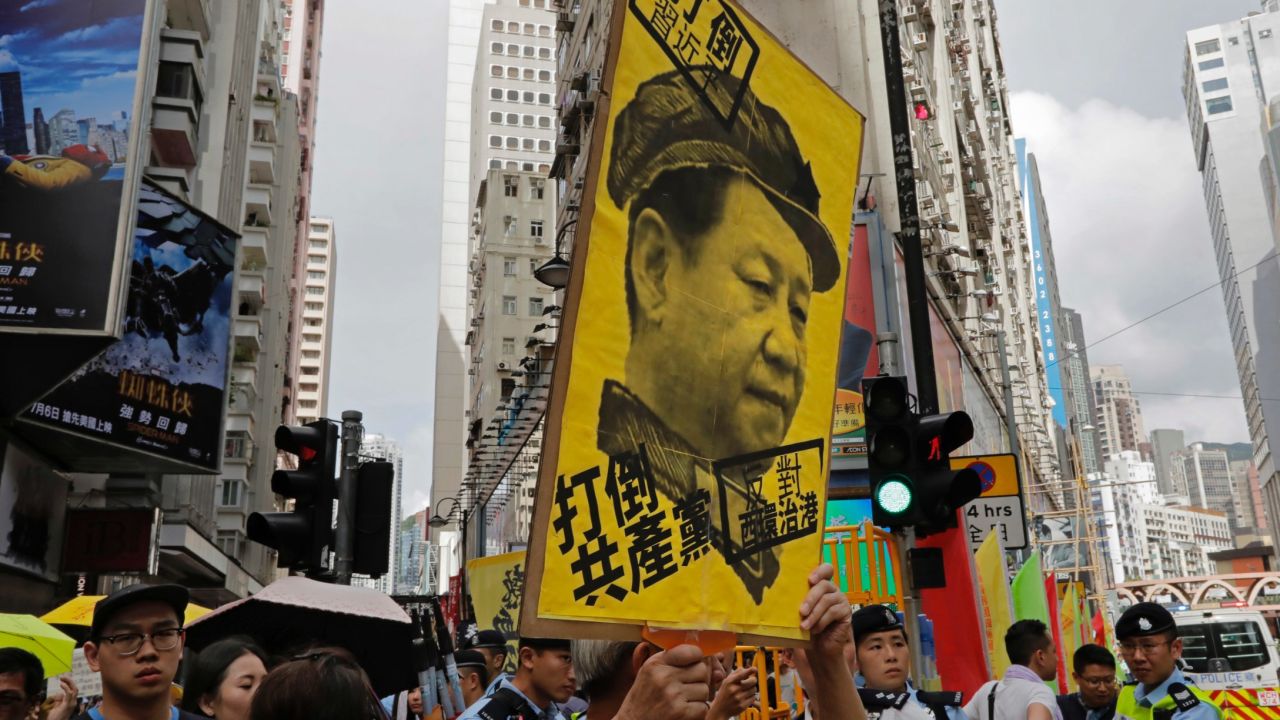 A protester raises a poster with Chinese President Xi Jinping's portrait as thousands march during the annual pro-democracy protest in Hong Kong, Saturday, July 1, 2017. 