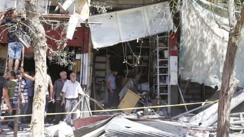 Syrians inspect the damage at the site of a suicide bomb attack in the capital Damascus' eastern Tahrir Square district.
