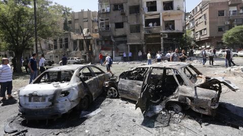 Charred vehicles are seen at the site of a suicide bomb attack in the Syrian capital's eastern Tahrir Square district.