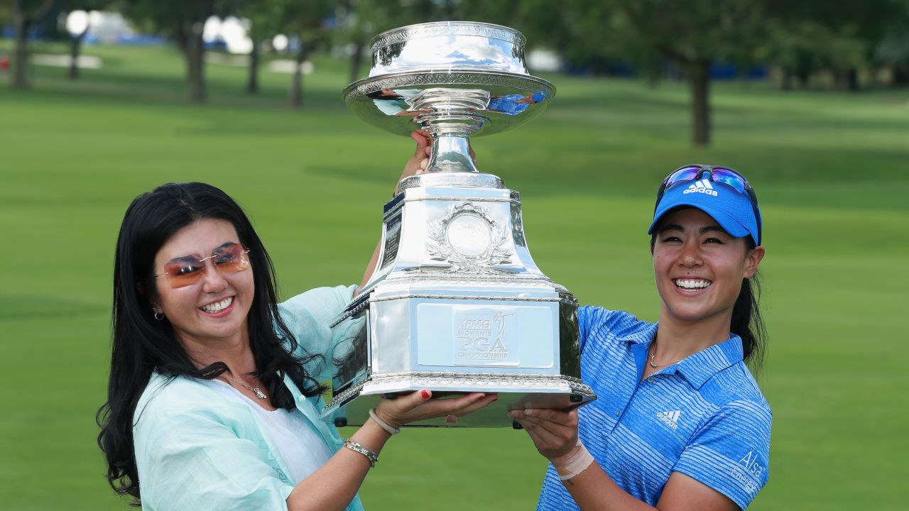 Kang lifts the trophy with her mother, Grace Lee.