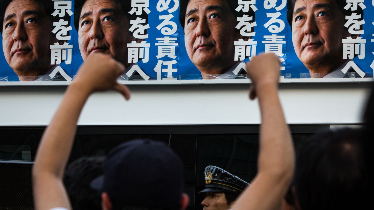 Voters react to Japanese Prime Minister Shinzo Abe's campaign posters during the Tokyo Metropolitan Assembly election.