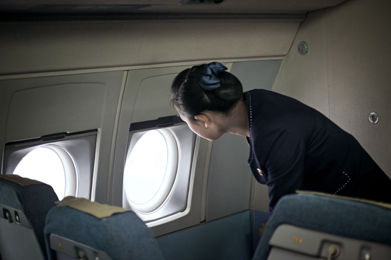 A flight attendant of the Ilyushin-62 checking on ground personal just after landing. "My experience is that North Koreans want you to come and see what they want you to see, have a good time, spend a few Euros, and leave with a positive impression of their country," says Mebius.